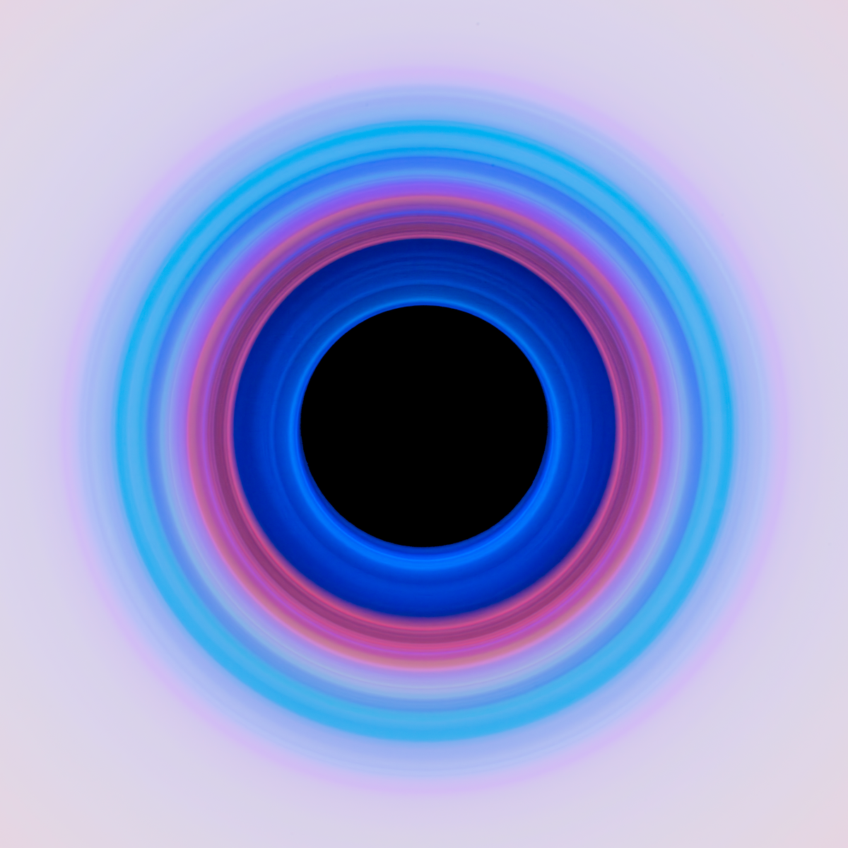 Abstract radial photograph showing a single wide band of blue and magenta light with a dark center void and soft edges fading to black