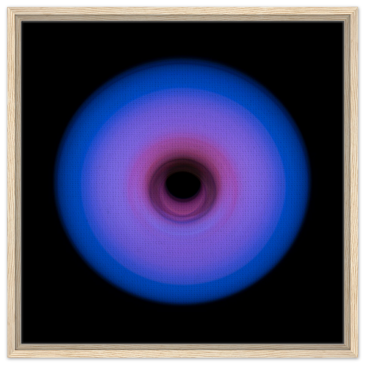 A circular ring of light with royal blue outer edges that gradually transitions through purple to pink toward a small dark center.
