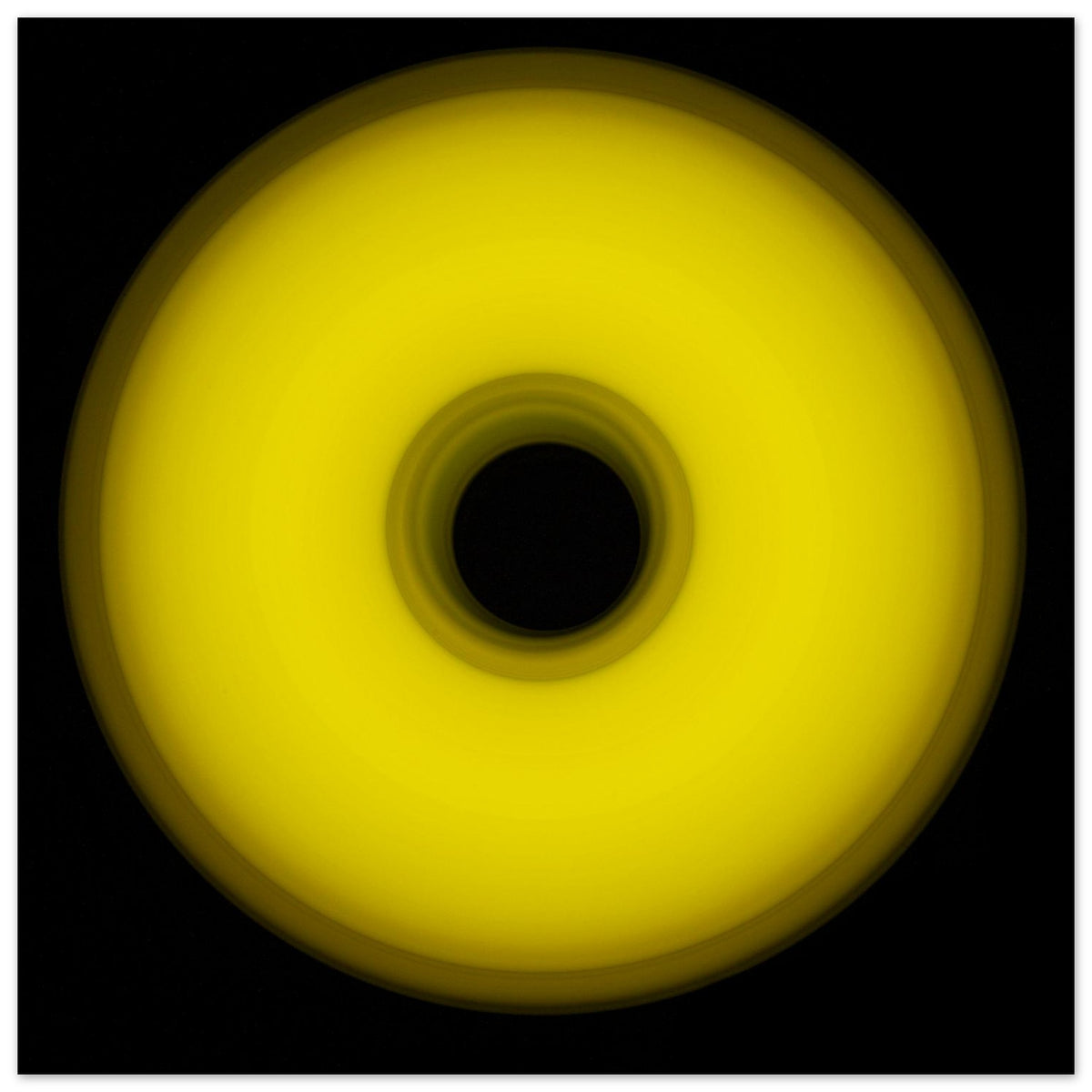 A circular yellow ring that gradients from bright yellow at the edges to olive green toward the dark center hole.