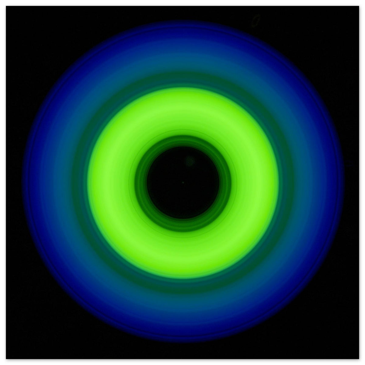A circular ring shape with bright lime green center transitioning through teal to cobalt blue outer edge with black center void.