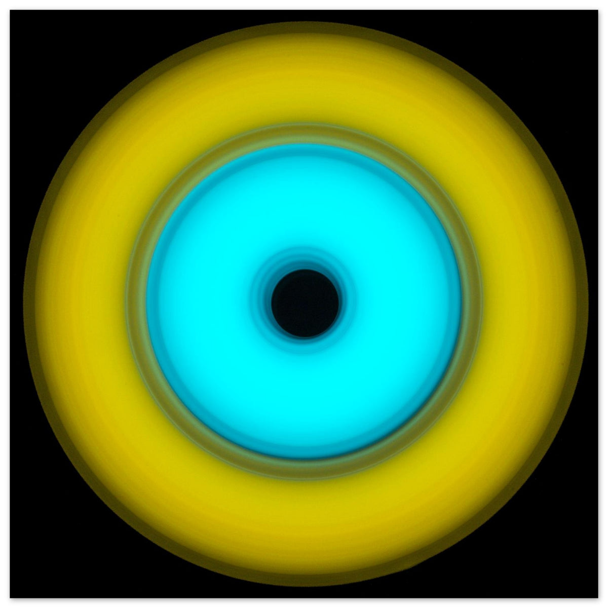 A circular aperture shape with bright yellow outer ring, electric cyan inner circle, and small black center hole against a black background.