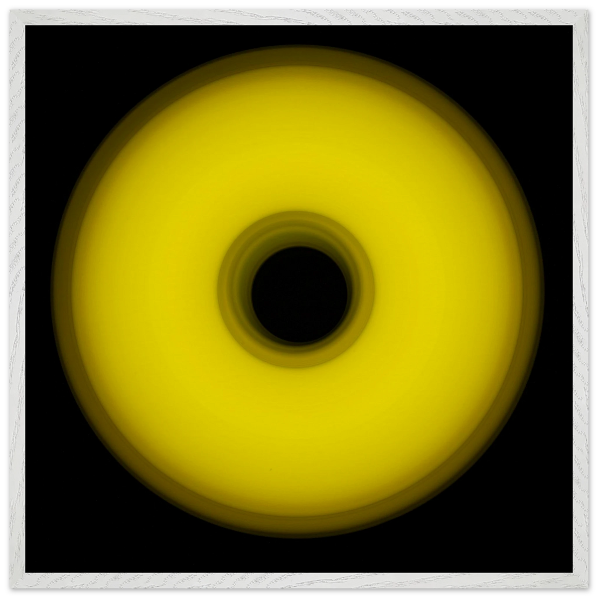 A circular yellow ring that gradients from bright yellow at the edges to olive green toward the dark center hole.